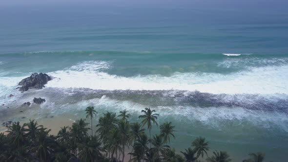 Endless Blue Ocean Waves with White Foam Roll on Coastline