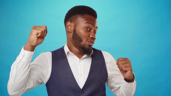 Pleased African Man in Shirt Dancing Against Blue Background