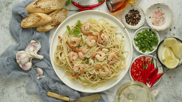 Spaghetti with Shrimps on White Ceramic Plate and Served with Glass of White Wine