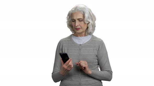 Smiling Senior Woman Using Smartphone on White Background