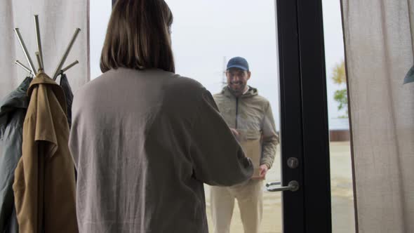 Delivery Man Giving Paper Bag to Customer at Home