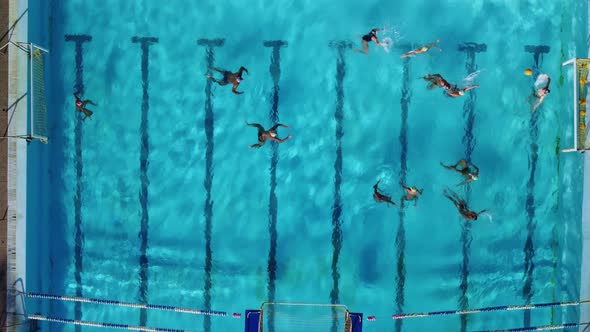 Aerial Drone Top View Shot of People Competing in Water Polo in Turquoise Water Pool