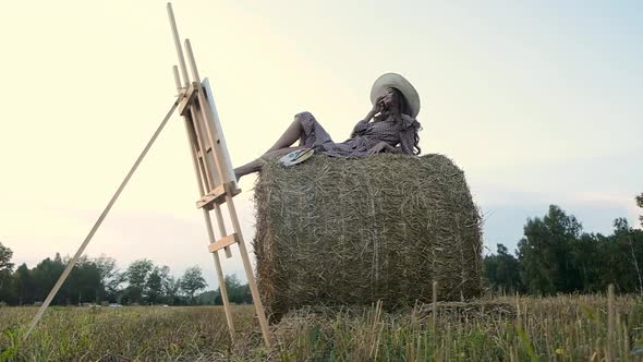 Creative female artist outside in a field in a summer sunset