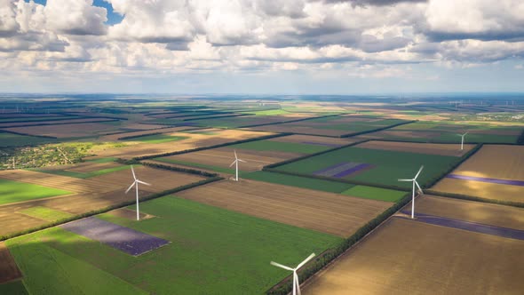 Hyper lapse above wind turbines across summer agricultural field