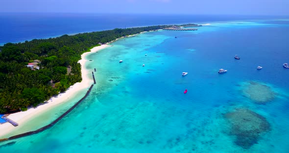 Tropical flying travel shot of a sunshine white sandy paradise beach and turquoise sea background in