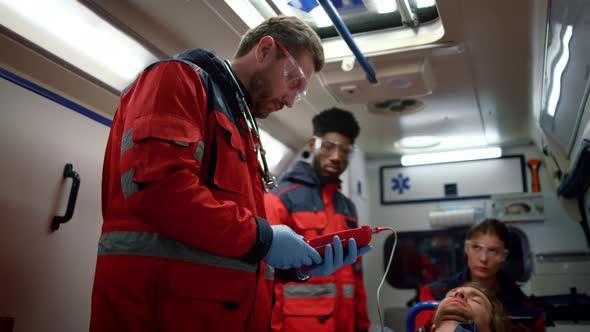 Mixed Race Paramedics Checking Oxygen Blood Saturation Level of Patient