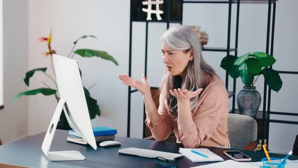 Senior Business Woman Confused with Stress Anxiety Overloaded on Computer at the Office