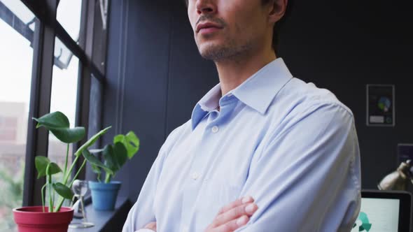 Caucasian businessman standing looking out of window in modern office