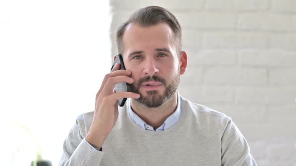 Portrait of Young Architect Celebrating Success on Smartphone