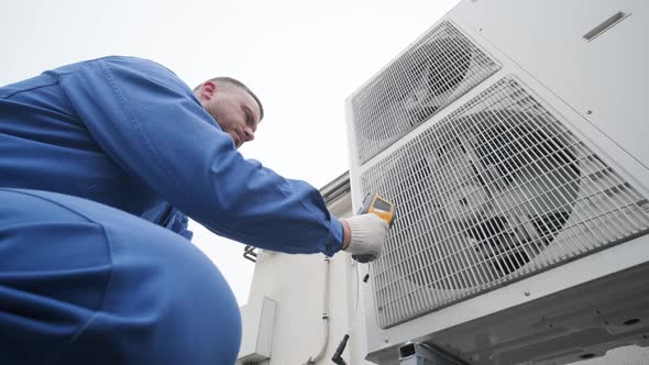 Technician uses a thermal imaging infrared thermometer to check the condensing