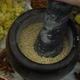 Woman's hand mixes and crushes sesame seeds by granite mortar - VideoHive Item for Sale