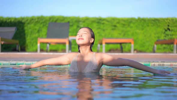 Young asian woman enjoy around outdoor swimming pool for leisure