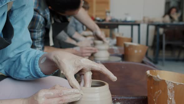Close-up Tilt-up of Young Woman Making Pot on Throwing-wheel in Pottery Class