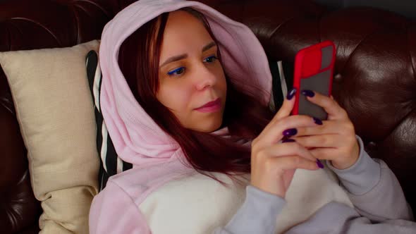 Woman Browsing Smartphone on Couch