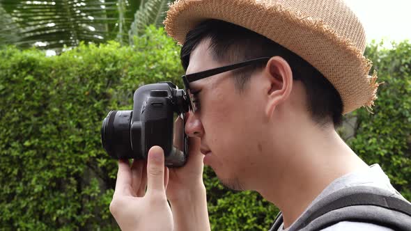 Rear Side View of Young Male Travel Photographer Tourist Taking Photos in Nature Scenery