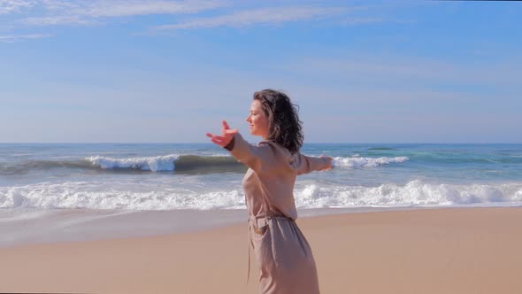 Happy Woman Having Fun with Arms Up on Beach in Summer During Holidays Travel