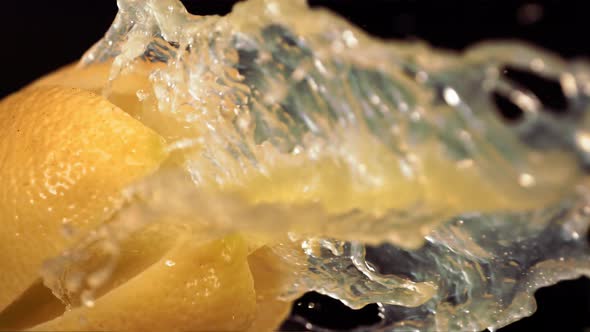 Fresh Lemon Fruit Squirting with Juice in Slow Motion in Black Background