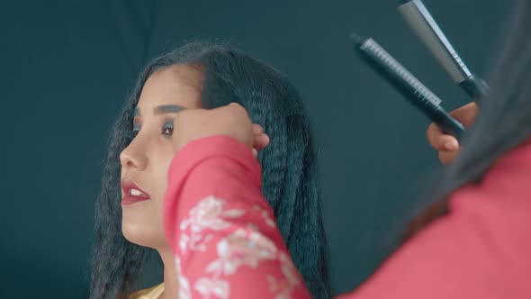 Close up of young woman in cosmetics studio and make up artist making a hairstyle