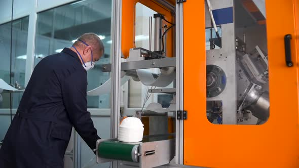 A man works at a machine for the manufacture of medical masks with nanofiber.
