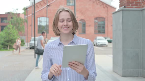 Woman Doing Video Chaton Tablet While Walking in Street