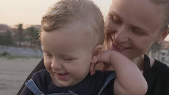 Happy and caring mum with baby daughter outdoor