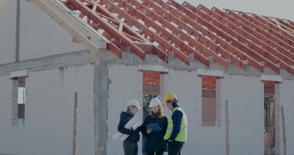 Supervisor and Worker Discussing Over Clipboard with Architect