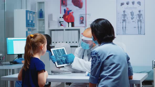 Physician Explaining X-ray Using Tablet