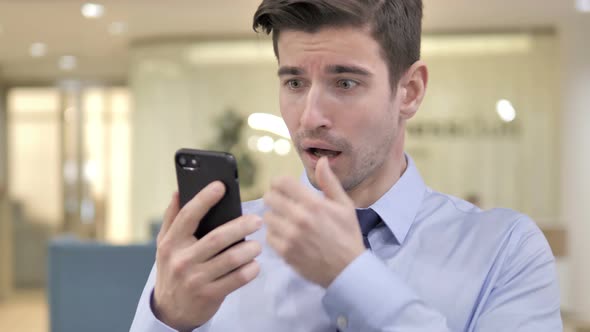 Businessman in Shock While Using Smartphone