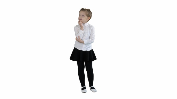 A curious little girl stands and thinks on white background.