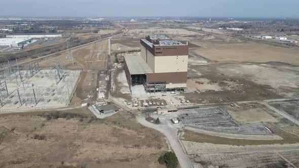 Panorama of old coal plant being deconstructed in Kenosha, Wisconsin. Railroad tracks. Hazy sky.