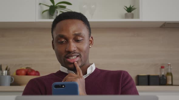 Happy Smiling African American Man Greeting His Friends on a Video Call on a Laptop at Home