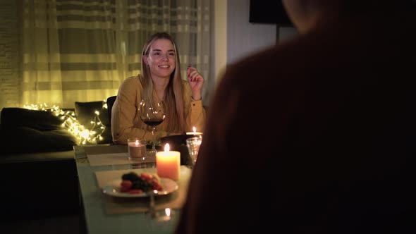 Portrait of a Young Caucasian Girl Over the Shoulder of a Man Sitting at a Table During a Romantic