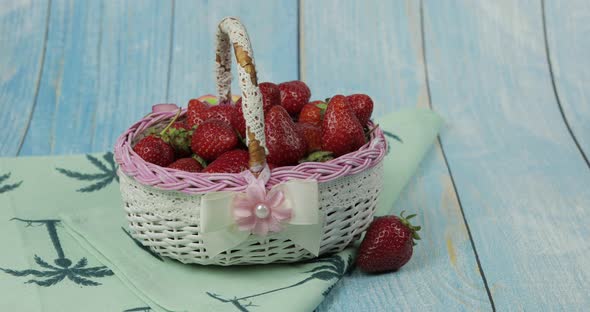 Strawberries in a Small Basket on the Blue Wooden Table