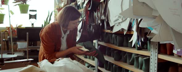 Woman Taking Last from Shelf in Shoemaking Workshop