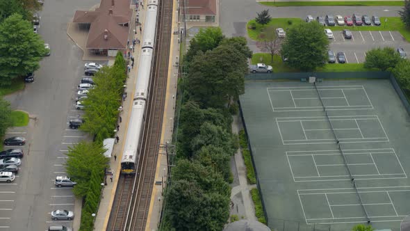Aerial View of MTA Train Arriving at Station Near Tennis Courts in Long Island