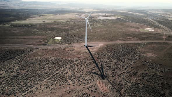 A tall wind powered electric turbine creates green sustainable carbon neutral electricity, aerial