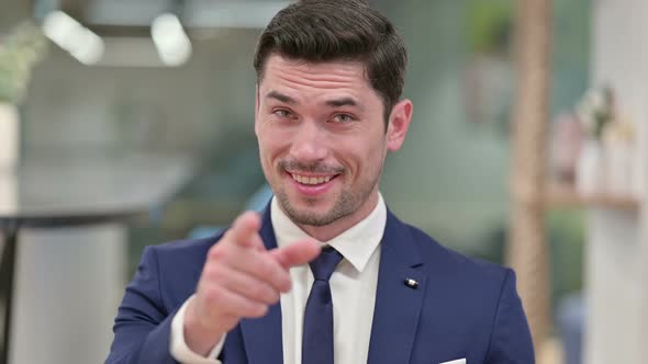 Assertive Young Businessman with Pointing and Inviting 