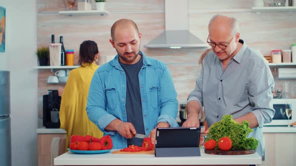 Men Cooking Using Tablet