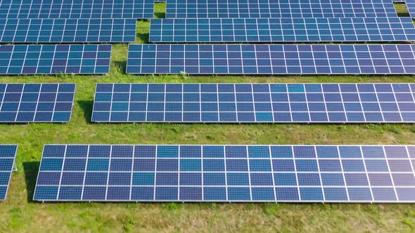 Flight Over a Field of Solar Panels in Sunny Summer Day