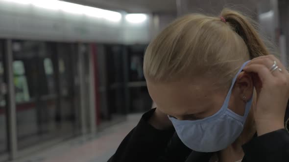 Woman Putting on Mask in the Subway