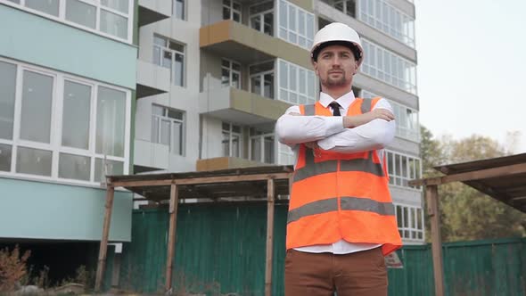 Business foreman at a construction site with his arms crossed over his chest.