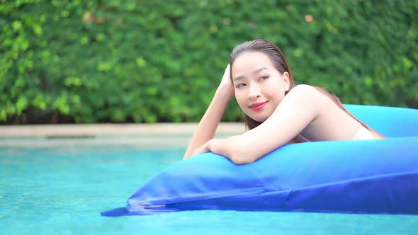 Young asian woman enjoy around outdoor swimming pool for leisure