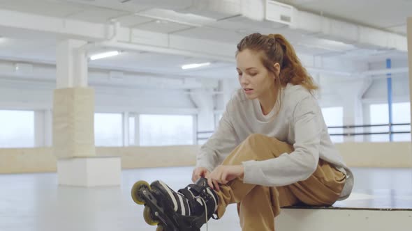 Young Woman Putting on Roller-Skates