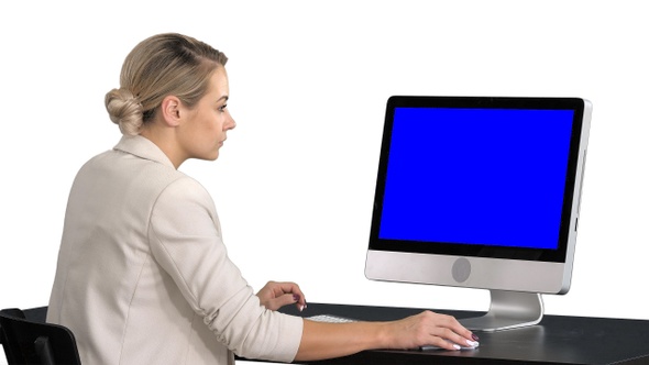 Young woman working in office sitting at desk, looking