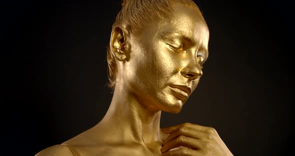 Young Woman Face with Closed Eyes and Skin of Golden Colour