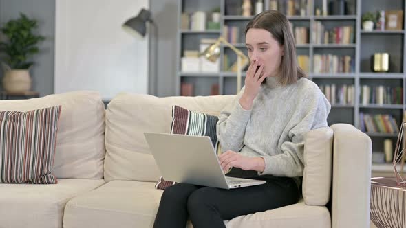 Young Woman Reacting To Failure on Laptop on Sofa