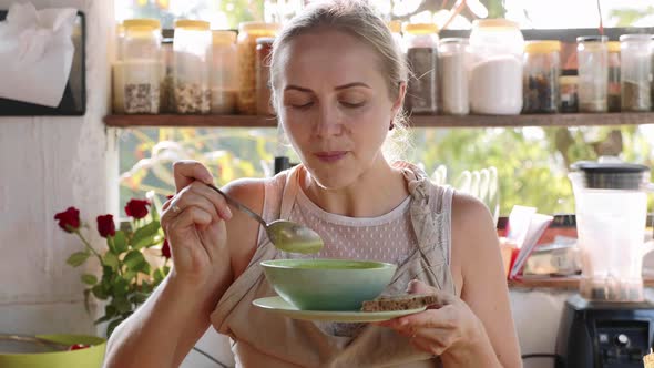 Young Happy Woman Tasting Just Preparing Food in the Kitchen