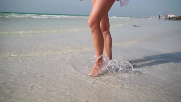 Slim Female Legs Walks Along Beach of Persian Gulf