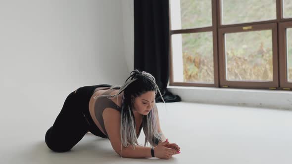 Happy Body Positive Fat Woman with Dreadlocks Doing Yoga in the Gym