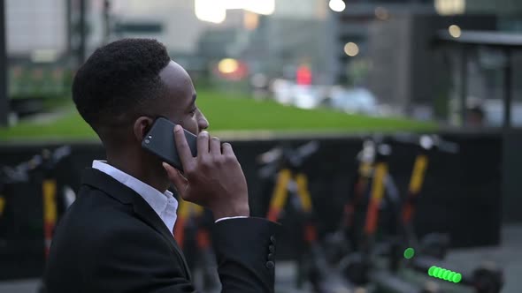 black guy walking in the business center and talking on the phone